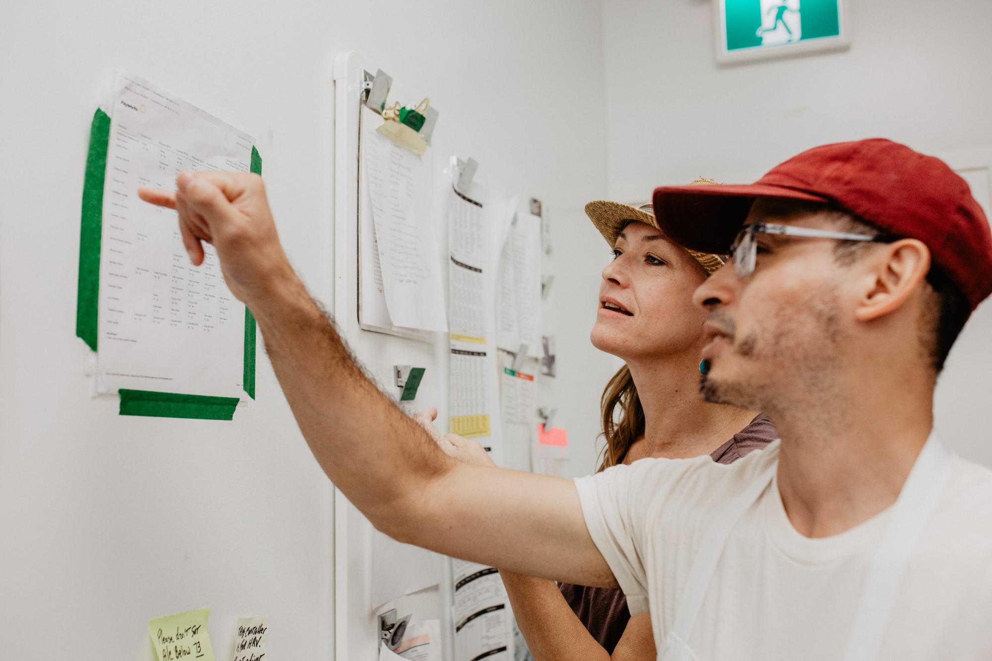 Julio pointing to a document on the wall